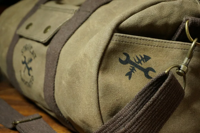 Detail: outside pocket with logo and snap hook on the shoulder strap.