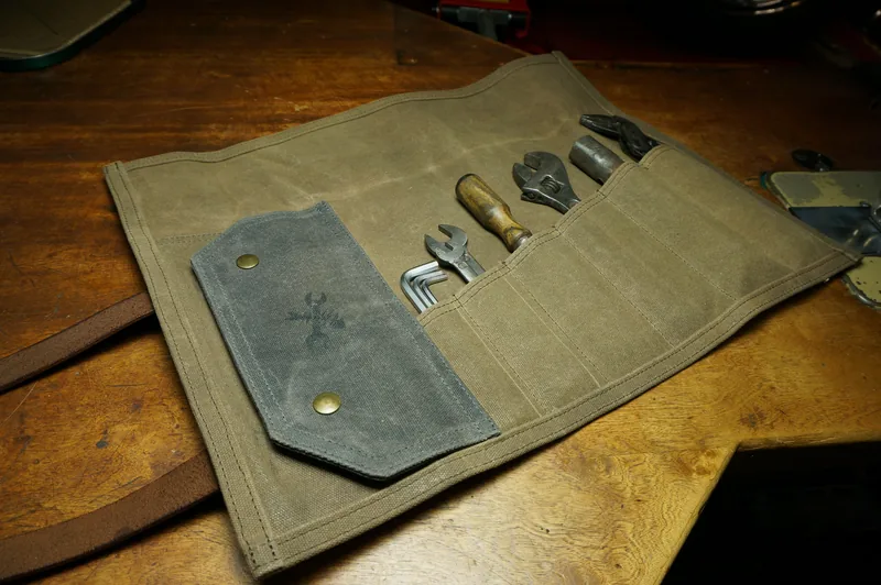 Unrolled Tool Roll „Nine Lives“ in Desert Tan, filled with tools.
