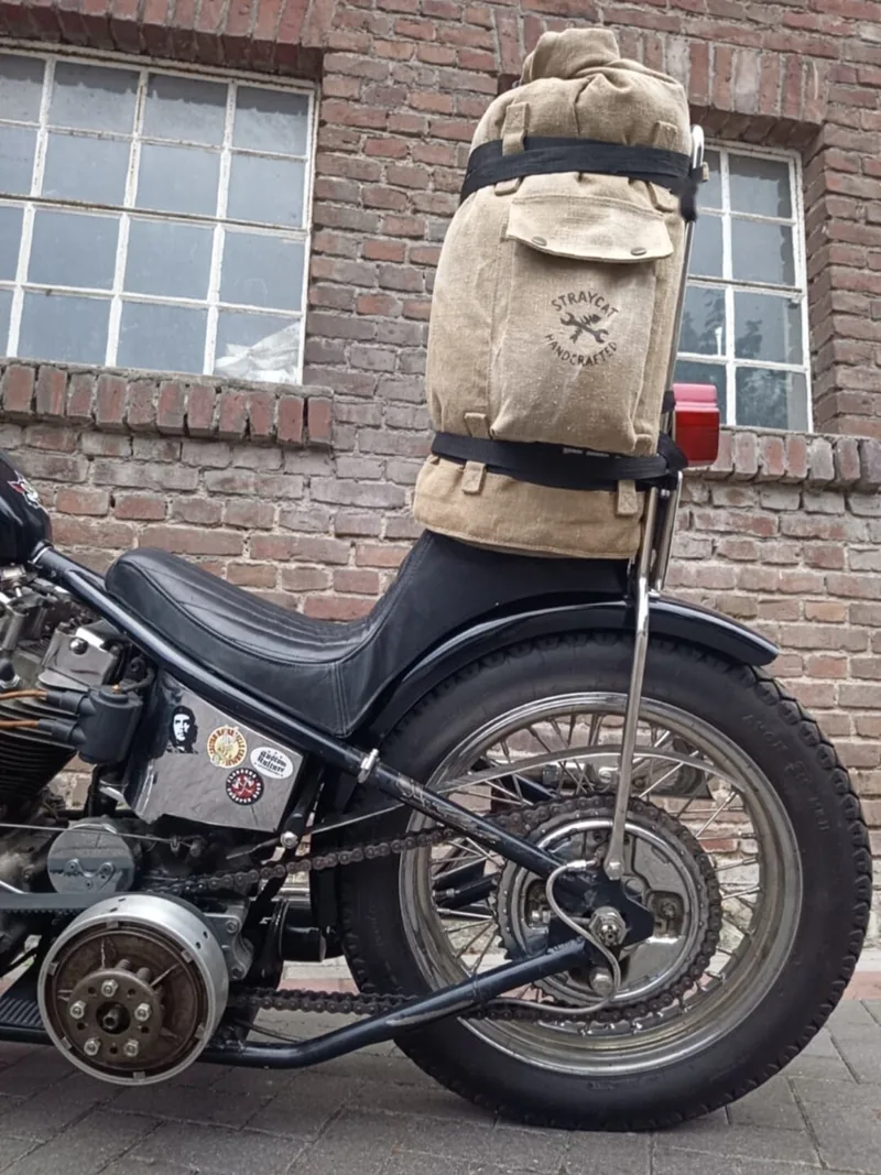 Sissybar Bag seitlich: Canvas-Tasche mit Siebdruck-Logo und Gurten, festgeschnallt an der Sissybar eines Motorrads.