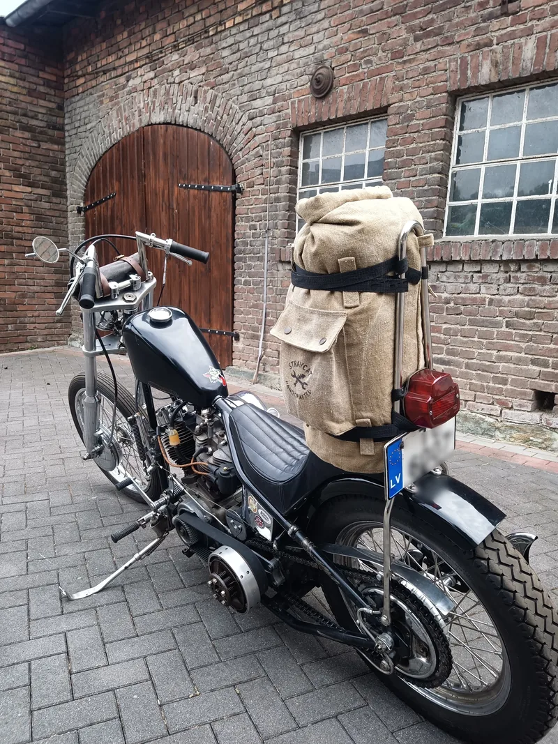 Motorrad von hinten vor einer Backsteinwand, auf dem Heck die Sissybar Bag.