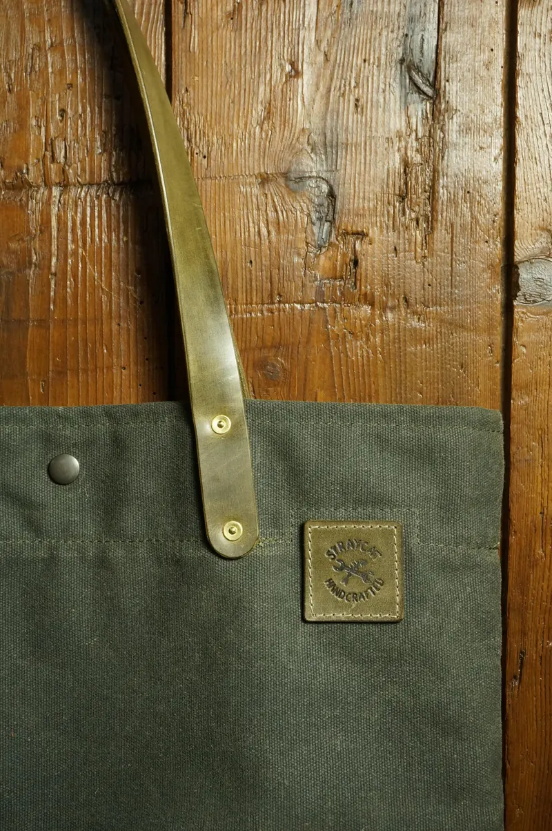 Detail: leather handle with rivet and leather patch with logo.