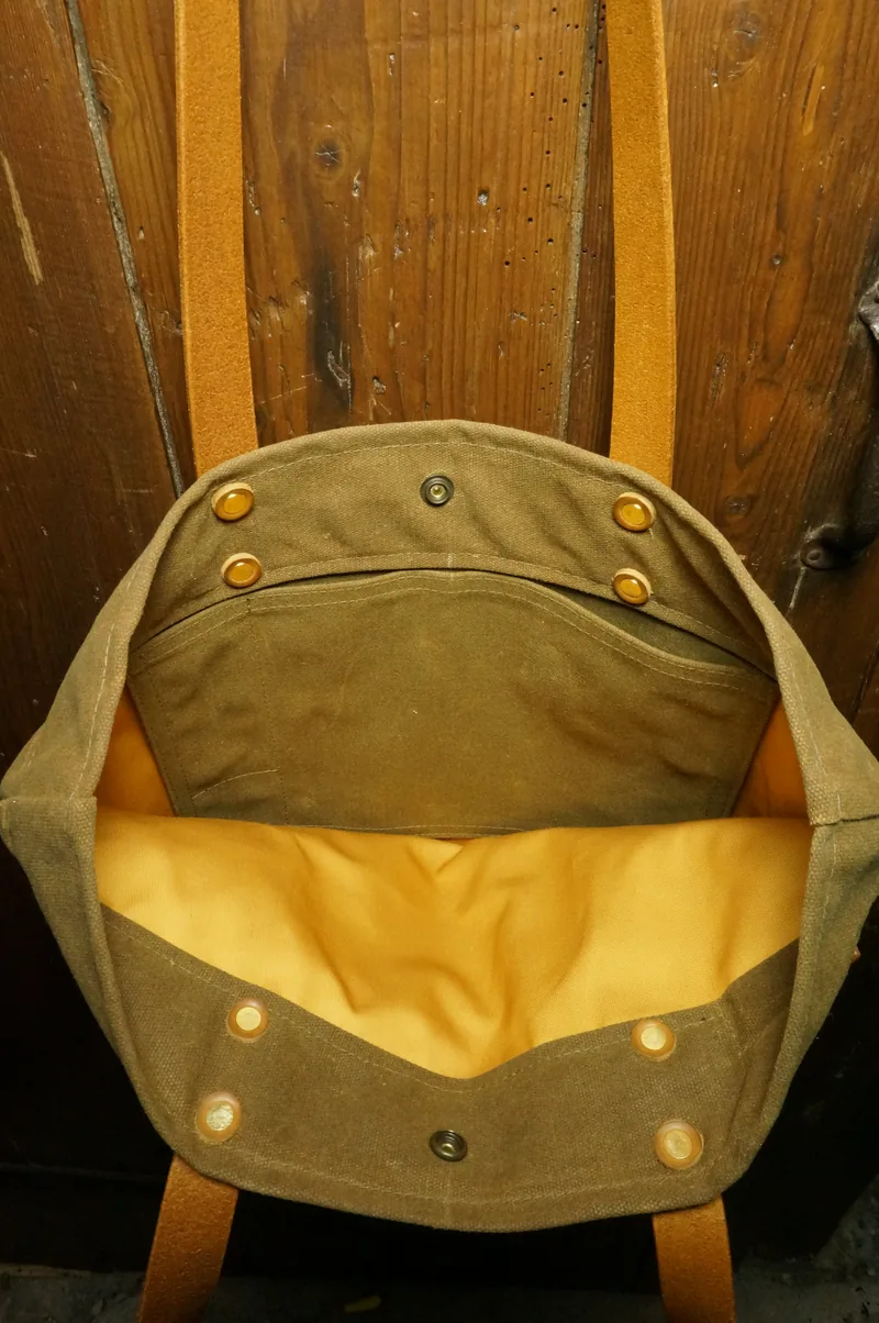Open ochre tote bag with yellow lining, inside pocket and press stud.