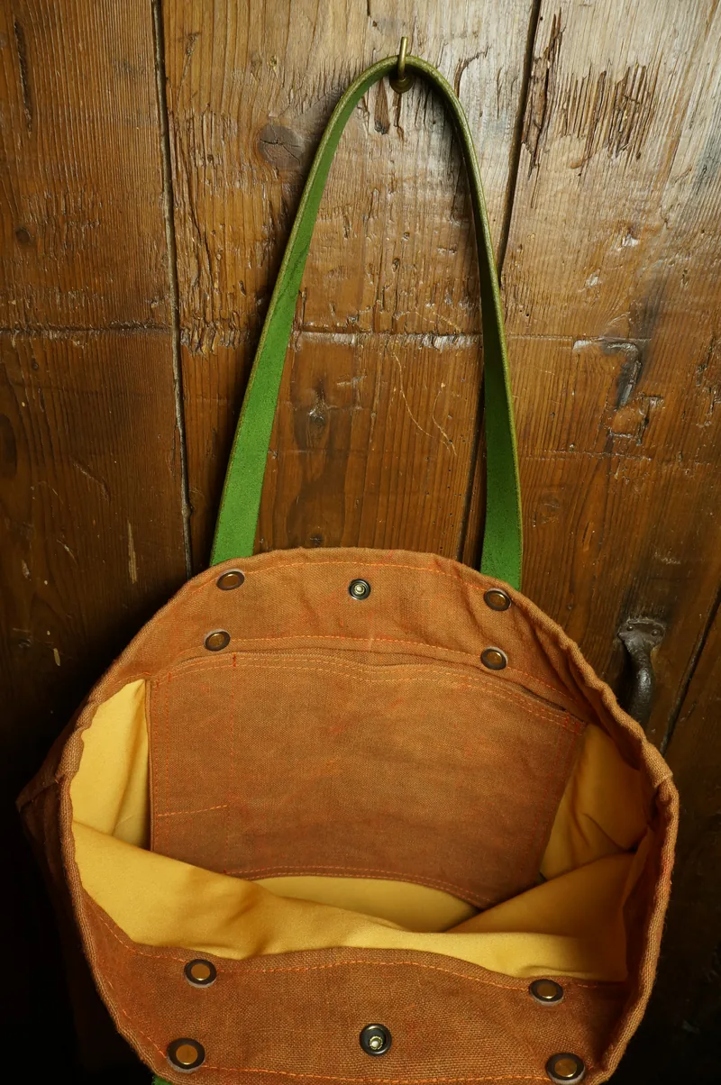 Open Tent Orange tote bag with yellow lining and press studs.